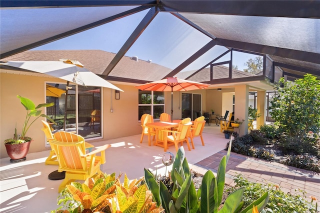 view of patio featuring glass enclosure and outdoor dining space