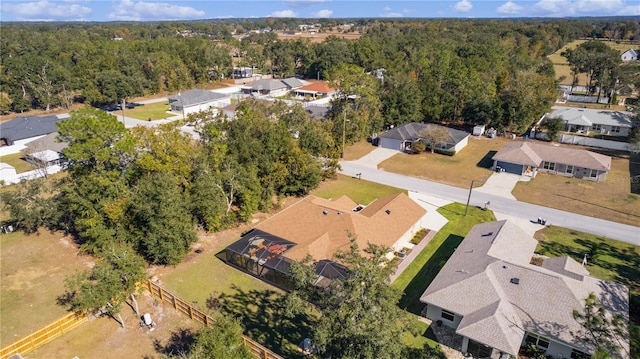 drone / aerial view featuring a residential view and a view of trees