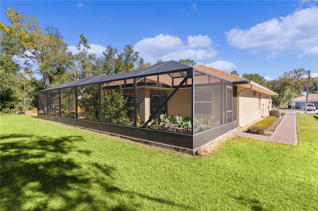 back of house with glass enclosure, a lawn, and central air condition unit