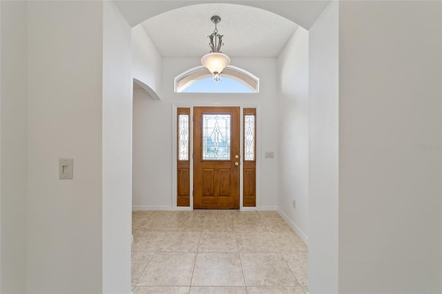 tiled foyer entrance with a textured ceiling