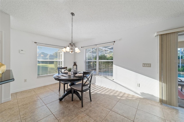 dining space featuring a notable chandelier, a textured ceiling, and light tile patterned flooring