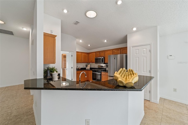 kitchen with light tile patterned flooring, sink, vaulted ceiling, kitchen peninsula, and stainless steel appliances