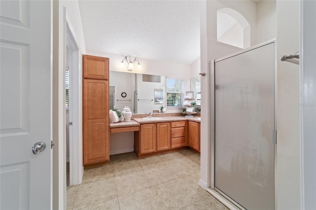 bathroom with vanity, a shower with shower door, tile patterned floors, and a textured ceiling