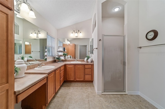 bathroom featuring walk in shower, vaulted ceiling, a textured ceiling, vanity, and tile patterned flooring