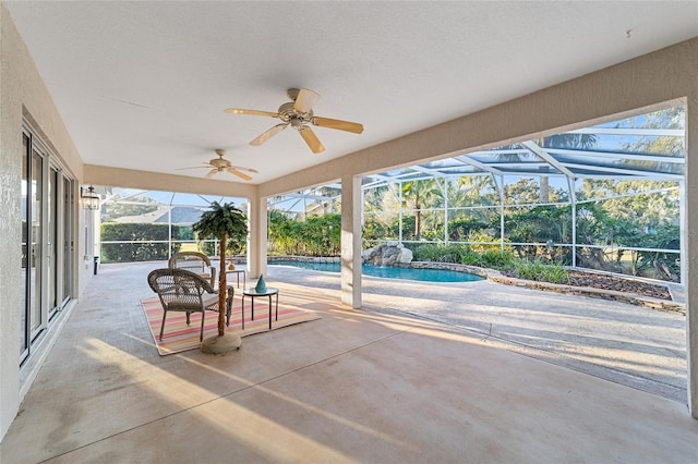 view of patio / terrace featuring ceiling fan and glass enclosure