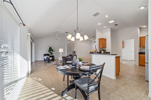 dining room with ceiling fan, vaulted ceiling, and light tile patterned floors