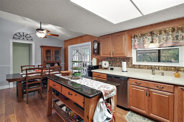 kitchen with ceiling fan, sink, light hardwood / wood-style flooring, stainless steel dishwasher, and a textured ceiling