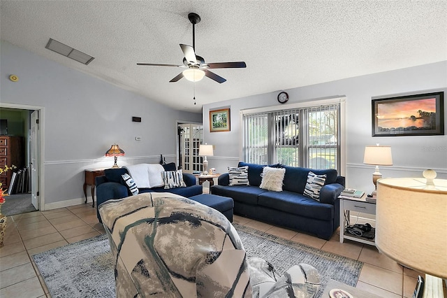 tiled living room featuring a textured ceiling, ceiling fan, and lofted ceiling