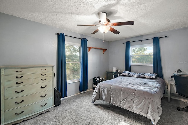 bedroom featuring ceiling fan, light colored carpet, and a textured ceiling