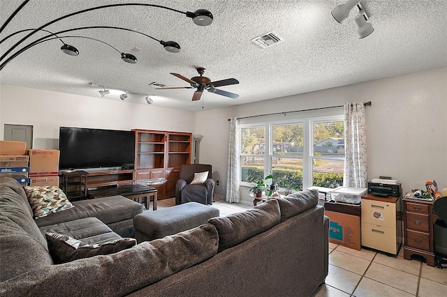 living room featuring a textured ceiling, ceiling fan, light tile patterned flooring, and track lighting