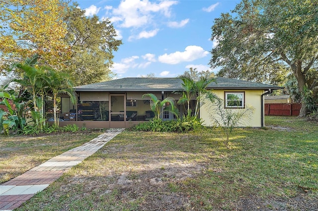 view of front facade featuring a sunroom and a front yard