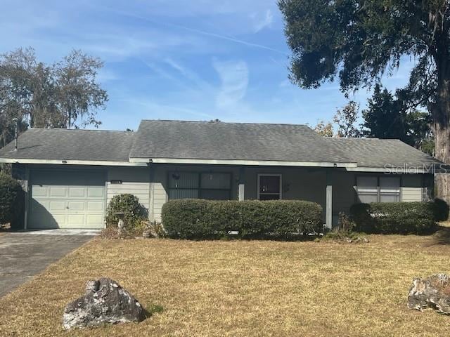 single story home featuring a garage and a front lawn