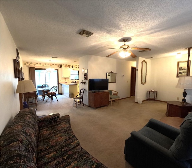 carpeted living room with ceiling fan and a textured ceiling