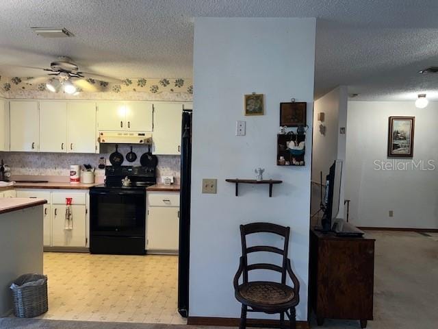 kitchen with electric range, white cabinetry, backsplash, and a textured ceiling