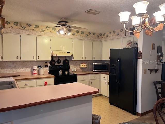 kitchen with black appliances, ceiling fan with notable chandelier, white cabinets, a textured ceiling, and kitchen peninsula