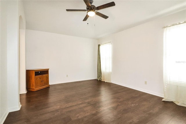 empty room featuring dark hardwood / wood-style flooring, ceiling fan, and plenty of natural light