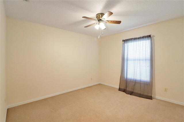 spare room with light colored carpet and ceiling fan