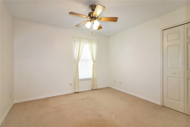 spare room featuring ceiling fan and light carpet