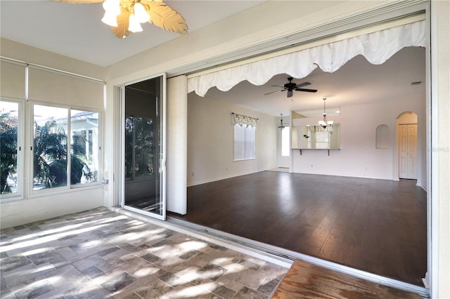 interior space with hardwood / wood-style floors and ceiling fan with notable chandelier