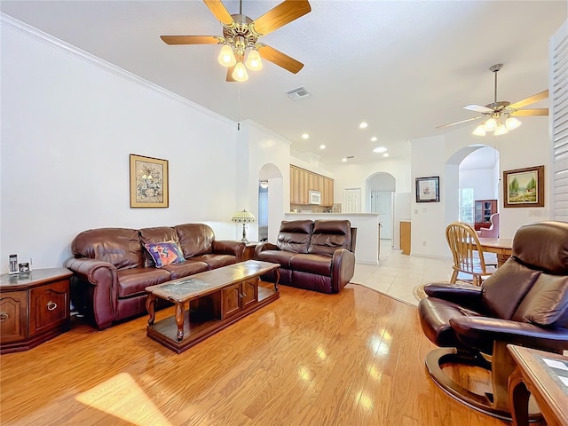 living room with light hardwood / wood-style flooring, ceiling fan, and ornamental molding