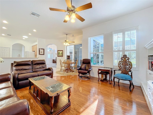 living room featuring ceiling fan and light hardwood / wood-style floors