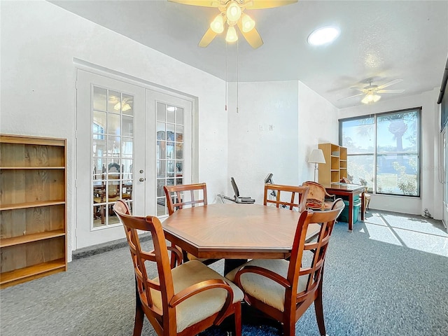 dining area featuring ceiling fan, french doors, and light carpet