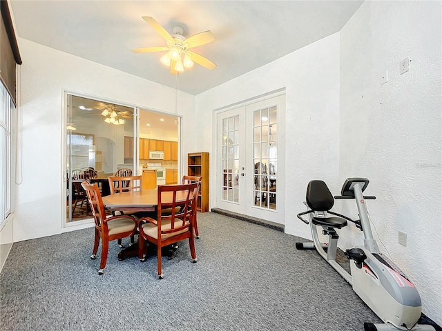 dining room with carpet flooring, ceiling fan, and french doors