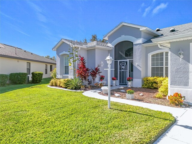 view of front of house featuring a front lawn and stucco siding