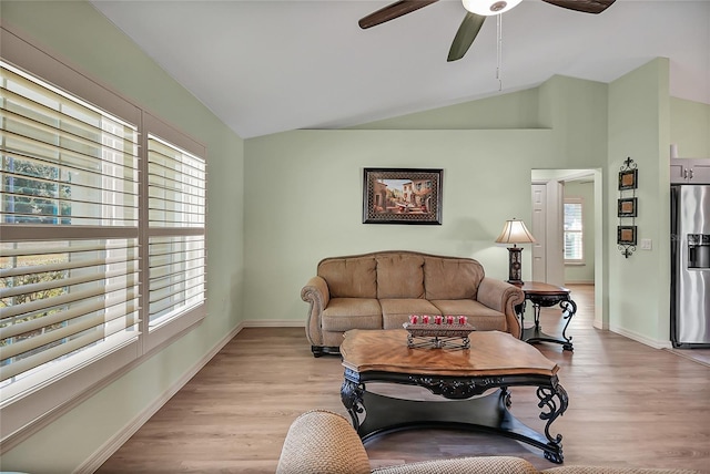 living room with light hardwood / wood-style floors, vaulted ceiling, a wealth of natural light, and ceiling fan