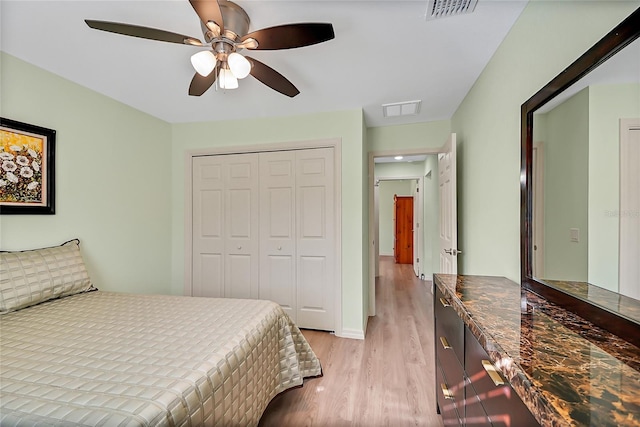 bedroom with ceiling fan, a closet, and light hardwood / wood-style flooring