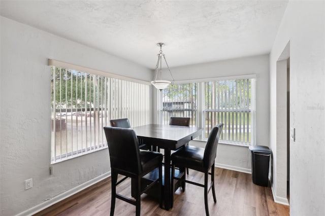 dining space with dark wood-type flooring and a textured ceiling