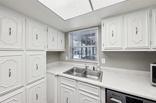 kitchen featuring stainless steel dishwasher, white cabinetry, and sink