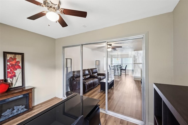 workout room featuring ceiling fan and light hardwood / wood-style flooring