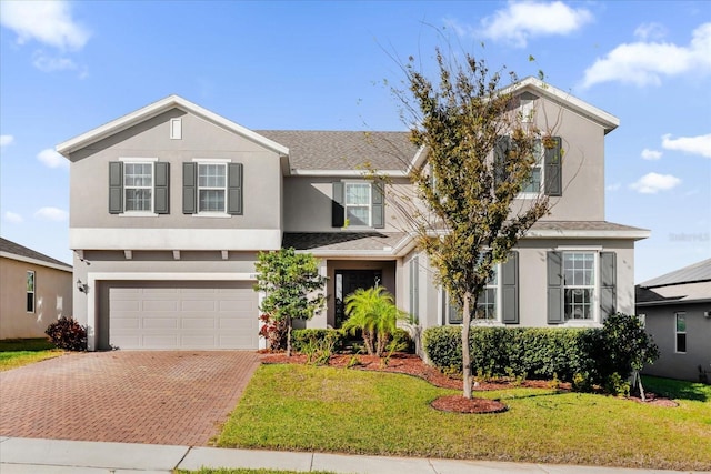 view of property with a garage and a front lawn