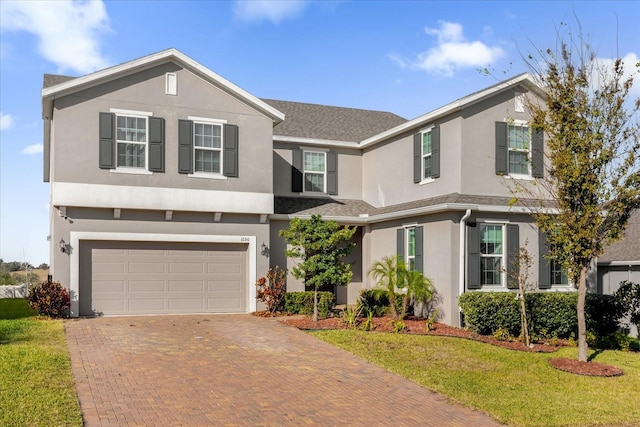 view of property with a garage and a front lawn