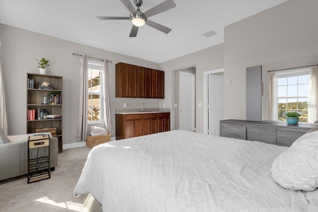 carpeted bedroom featuring ceiling fan and sink