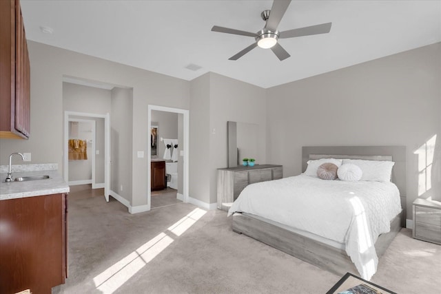 carpeted bedroom with connected bathroom, ceiling fan, and sink