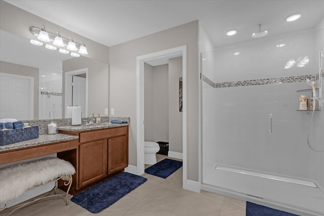 bathroom with vanity, toilet, tile patterned flooring, and walk in shower