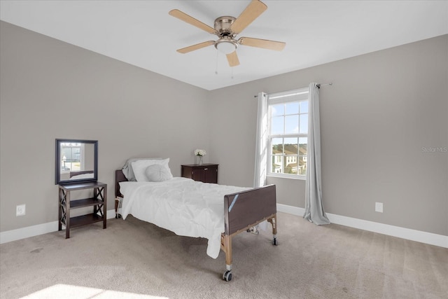 carpeted bedroom featuring multiple windows and ceiling fan