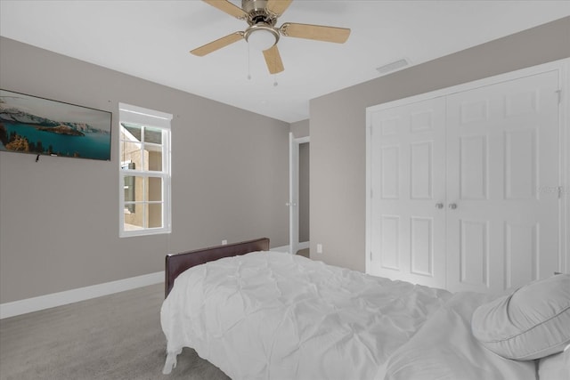 bedroom with ceiling fan, light colored carpet, and a closet