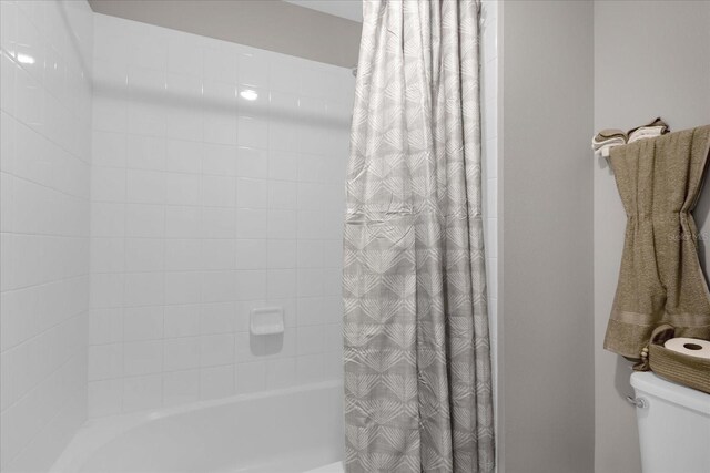 bathroom featuring toilet and shower / bath combo with shower curtain