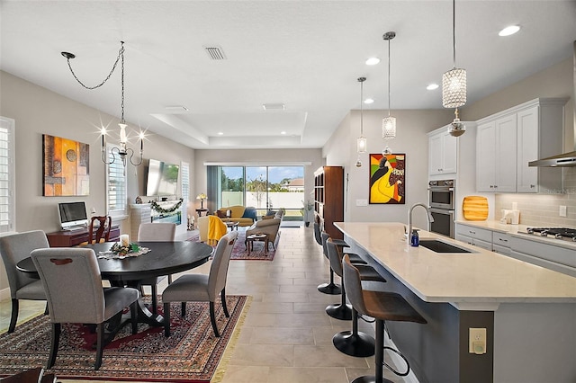 dining space featuring visible vents, a raised ceiling, a notable chandelier, and recessed lighting