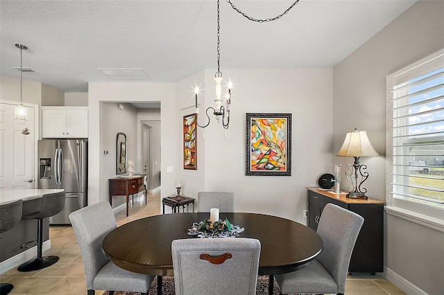 dining space with light tile patterned floors, baseboards, a chandelier, and a wealth of natural light