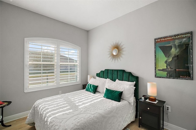 bedroom with baseboards and wood finished floors