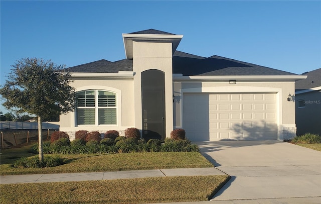 view of front of home with driveway, roof with shingles, a garage, and stucco siding