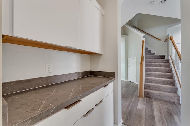 bar featuring white cabinets and wood-type flooring