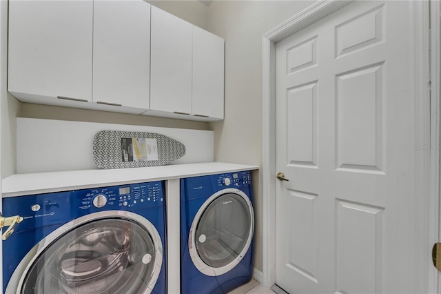 laundry area featuring washer and clothes dryer and cabinets