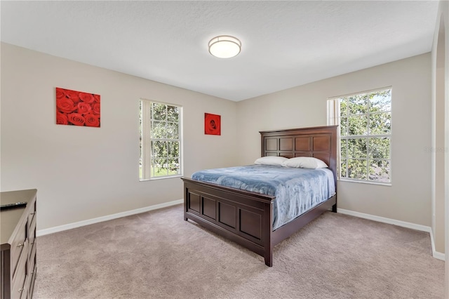 carpeted bedroom featuring multiple windows