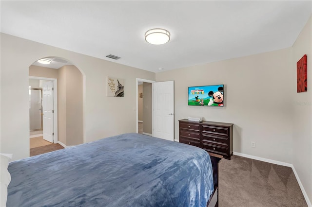 bedroom featuring light carpet and connected bathroom