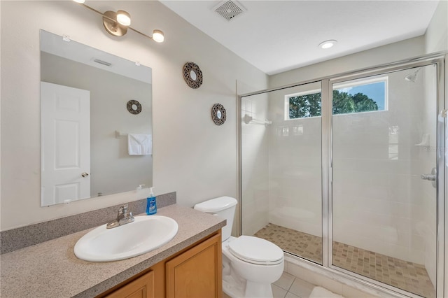 bathroom featuring tile patterned flooring, vanity, a shower with door, and toilet